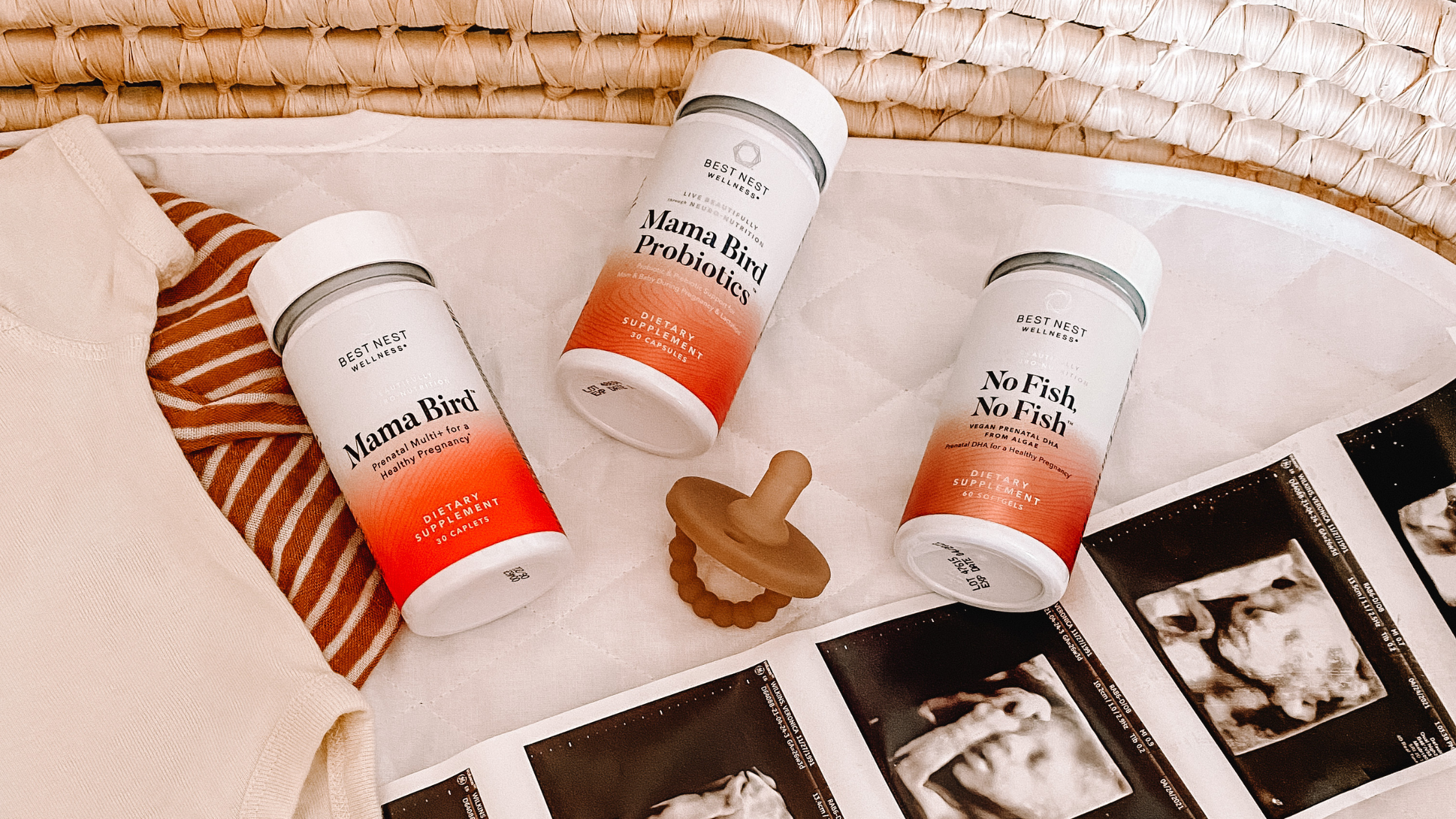 A group of bottles, including a white bottle with a red and white label, next to a brown baby pacifier with a rubber ring.