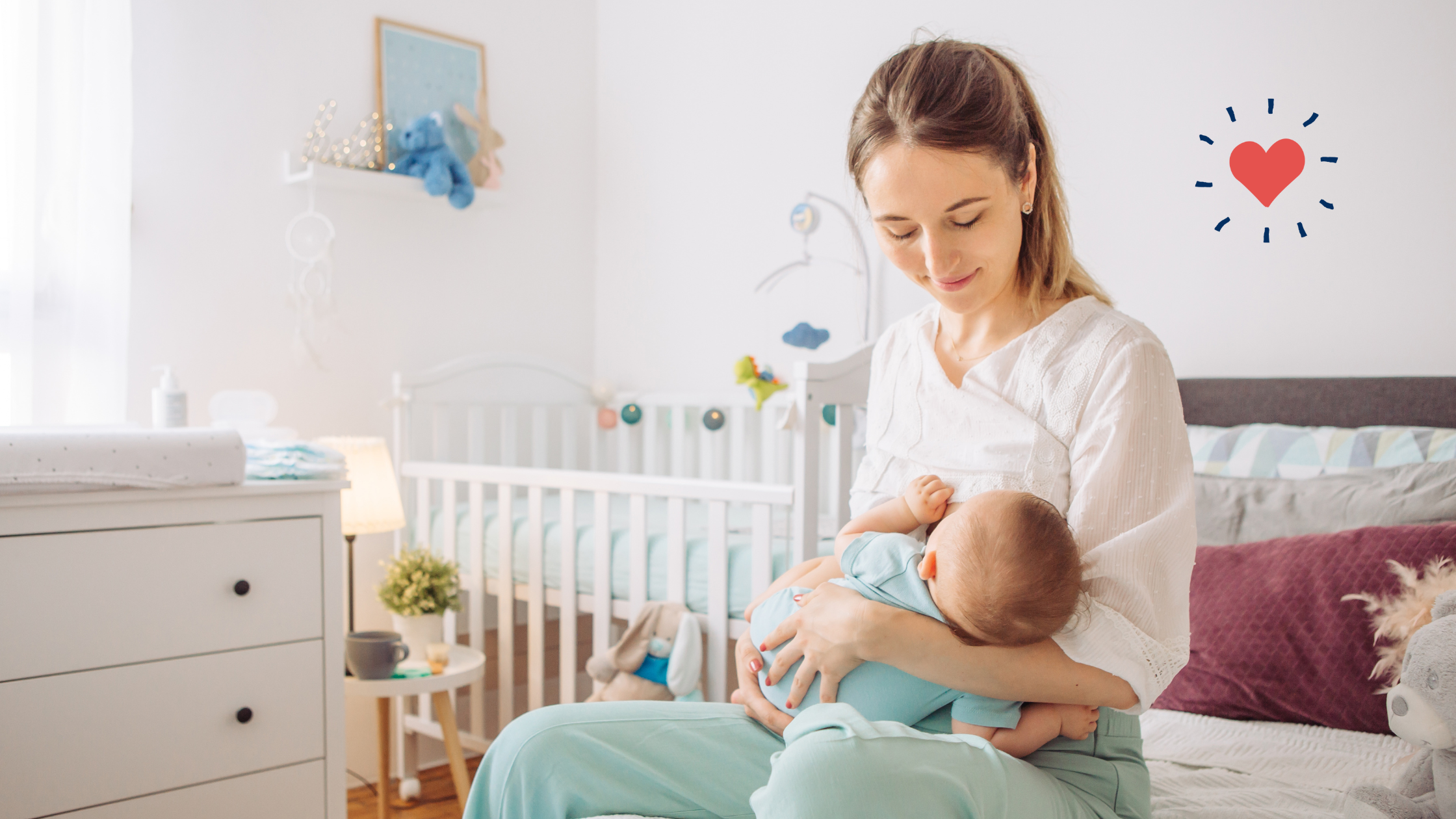 A woman holds a baby beside a white dresser with black knobs in a nursery.