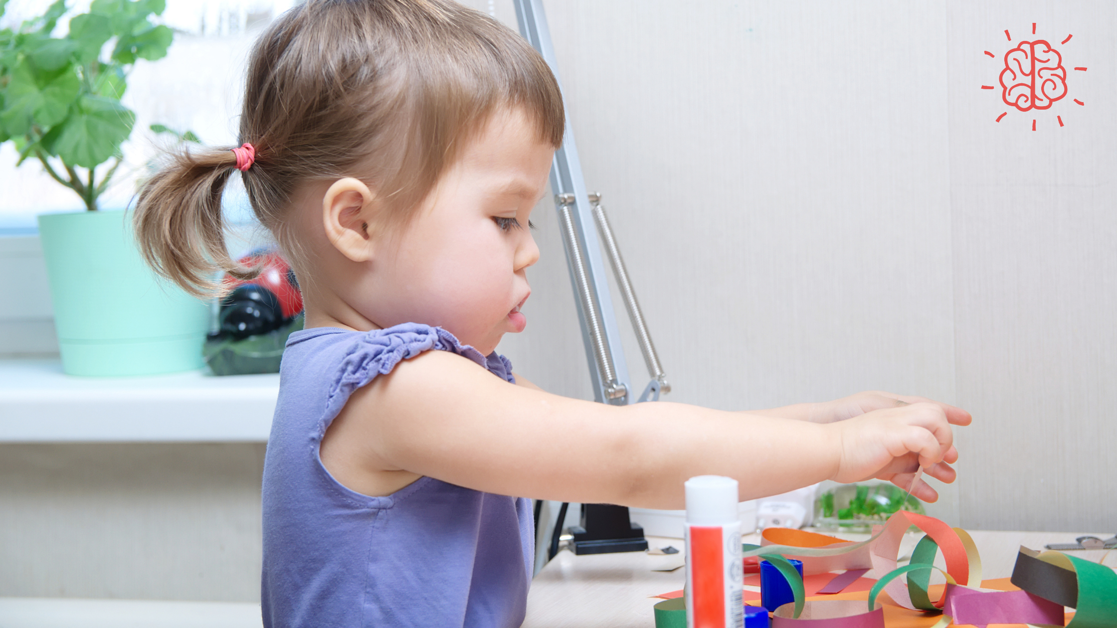 A toddler in a purple shirt playing with toys indoors, with a close-up of a white bottle visible in the background.