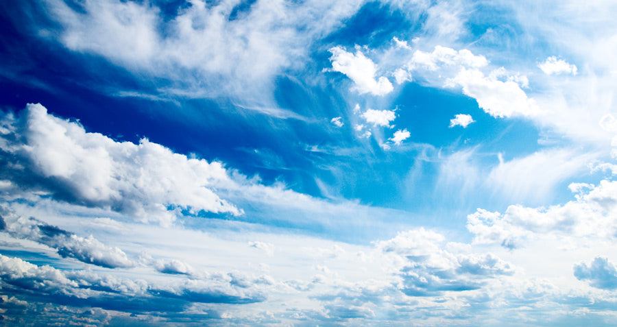 Blue sky with scattered cumulus clouds during daytime. The scene captures a clear, natural outdoor landscape.