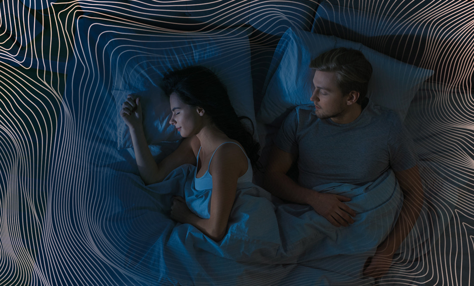 A man and woman peacefully sleeping in bed, both covered in light blue sheets, with their heads resting on pillows.