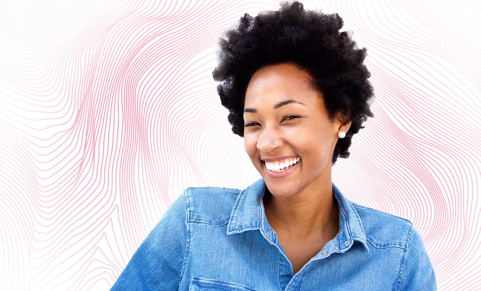 A close-up of a smiling woman with curly hair, showcasing her teeth and neck, wearing casual clothing.